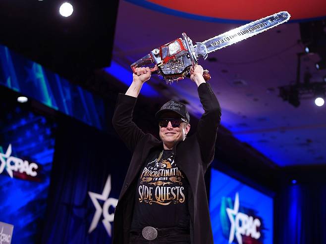 일론 머스크는 미국의 보수적인 성향의 정치 행사인 '보수정치행동회의(CPAC)' 무대에서 머리 위로 전기톱을 들어 올렸다