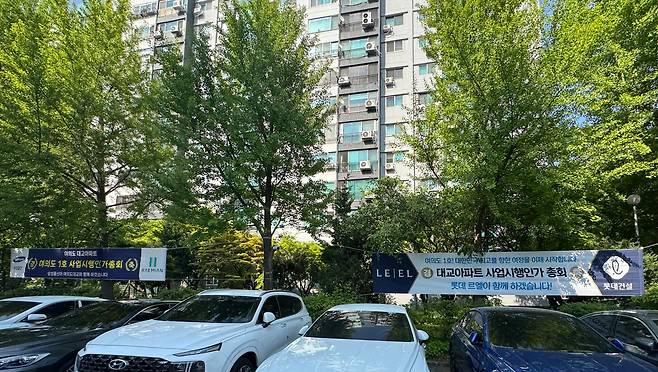 28일 오후 3시 서울 영등포구 여의도동 대교아파트 단지 안에 삼성물산과 롯데건설이 사업시행인가 총회를 축하하는 현수막이 각각 걸려있다. /사진=박지윤 기자