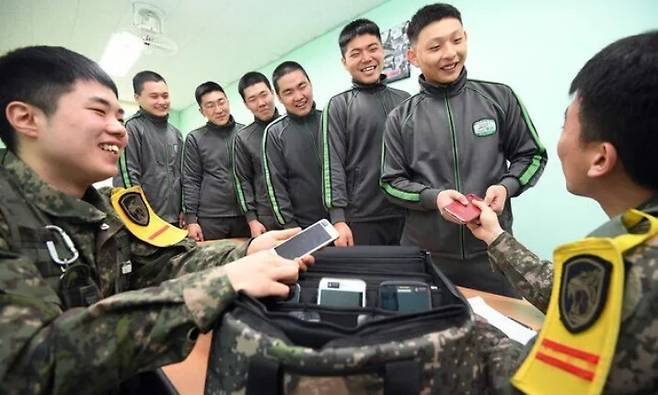 지난 2019년 간1월 경기도 가평군 육군 수도기계화보병사단 혜산진부대에서 오후 일과를 마친 병사들이 당직사관에게 휴대전화를 건네받고 있다. 당시는 병사 휴대전화 사용 자체가 금지됐는데, 이 부대는 2020년 7월 시행된 일과후 병사 휴대전화 사용에 앞서 시범운영을 하고 있었다. 가평/사진공동취재단, 한겨레 자료사진