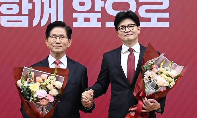 국민의힘 대선 최종 경선에 진출한 김문수(왼쪽)·한동훈 후보가 29일 서울 여의도 당사에서 3차 경선 결과 발표 후 꽃다발을 들고서 기념촬영 하고 있다. 연합뉴스