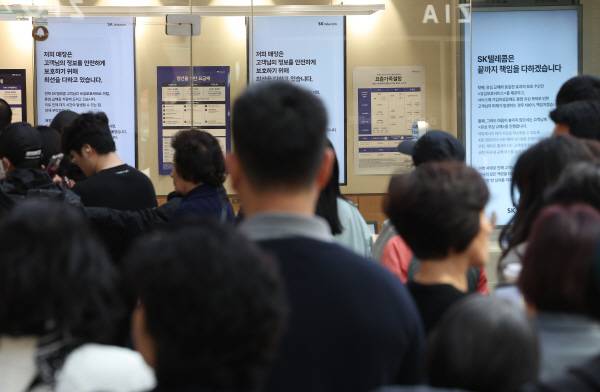 가입자 유심(USIM) 정보를 탈취당한 SK텔레콤이 유심 무료교체 서비스를 시작한 지 이틀째인 29일 서울 시내 한 SKT 대리점에 ‘SK텔레콤은 끝까지 책임을 다하겠습니다’라는 문구가 쓰여져 있다. 연합뉴스