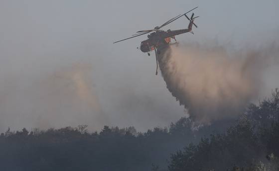 Helicopters drop water over the wildfire in Mount Hamji in Daegu on the morning of April 29. [YONHAP]