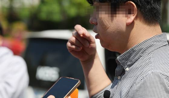 A 43-year-old parent surnamed Im, who was attacked by a student who had injured five others at a high school in Cheongju, North Chungcheong, earlier the same day, talks to reporters outside of the school on April 28. [YONHAP]