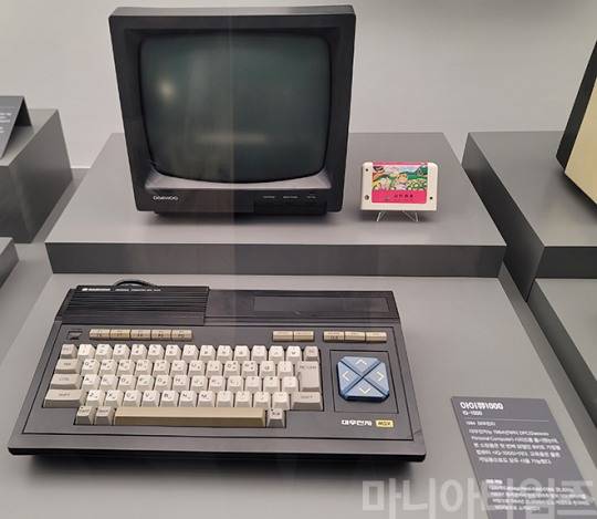 넷마블게임박물관. 1984년 출시된 대우전자의 MSX 규격 컴퓨터 '아이큐1000'. 기기 상단에 롬팩 카트릿지를 꼽을 수 있는 슬롯이 보인다. 사진 우상단의 팩은 1984년 발매된 코나미의 '양배추 인형'. 촬영 : 이동근 기자
