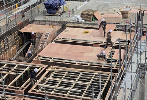 서울의 한 건설 현장에서 작업자들이 자재를 옮기고 있다.[사진 = 연합뉴스]