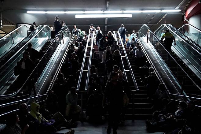 대규모 정전 사태로 열차 운행이 중단된 가운데, 스페인 마드리드 아토차역 계단에 앉아 쉬고 있는 시민들. 2025. 4. 28. [사진 = 로이터 연합뉴스]