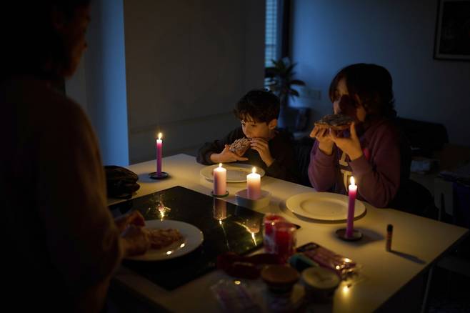 28일(현지시간) 스페인에서 대규모 정전 사태가 발생하자 바르셀로나의 한 가정집에서 가족이 촛불을 켜놓고 식사하고 있다. 이날 스페인과 포르투갈 전역에서 발생한 대규모 정전으로 기차, 지하철, 항공기 등 주요 교통수단이 마비되며 피해가 이어졌다. /AP=뉴시스