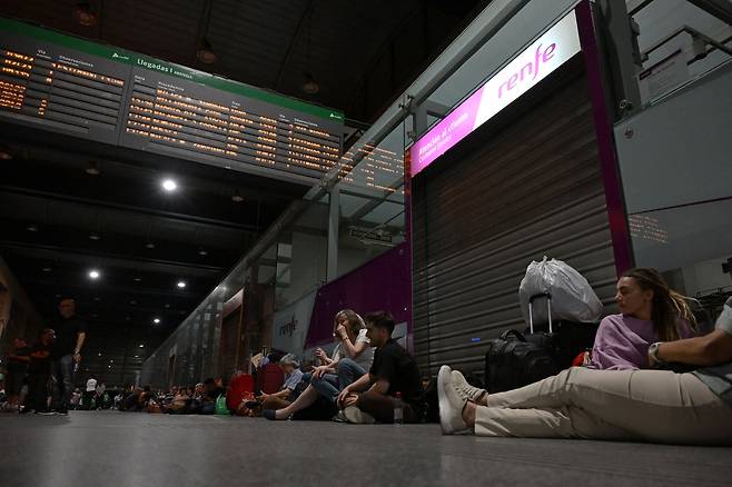 2025년 4월 28일, 대규모 정전으로 이베리아반도 전역과 프랑스 남부 일부 지역이 암흑에 빠진 가운데, 스페인 발렌시아 코르도바역에서 여행객들이 바닥에 앉거나 누워 밤을 보내고 있다. 페드로 산체스 스페인 총리는 이날 기자회견에서 “모든 가능성을 열어두고 정전 원인을 분석하고 있다”고 밝혔다. [AFP=연합]