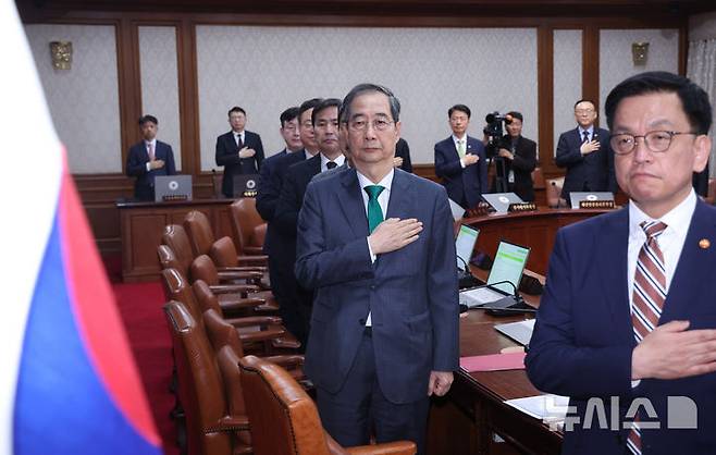 [서울=뉴시스] 조수정 기자 = 한덕수 대통령 권한대행 국무총리가 18일 정부서울청사에서 열린 추가경정예산안 심의 임시국무회의에서 국기에 경례하고 있다. 오른쪽은 최상목 경제부총리 겸 기획재정부 장관. 2025.04.18. chocrystal@newsis.com