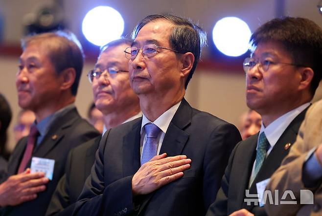 [서울=뉴시스] 최진석 기자 = 한덕수 대통령 권한대행 국무총리가 29일 서울 강남구 건설회관에서 열린 해외건설 1조달러 수주 및 60주년 기념식에서 국기에 경례하고 있다. 2025.04.29. myjs@newsis.com