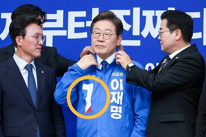 28일 더불어민주당 최고위원회의에 참석해 옷깃을 정리 중인 이재명 후보. 뉴스1