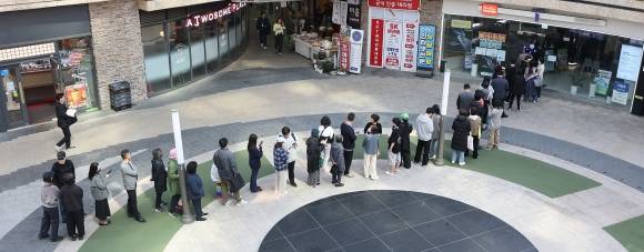 오늘은 교체할 수 있을까 - SK텔레콤의 유심 무료 교체 이틀째인 29일에도 서울의 한 SK텔레콤 대리점 앞에 유심을 교체하러 온 가입자들의 줄이 길게 늘어서 있다. 연합뉴스