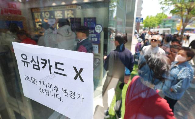 SK텔레콤이 유심 고객정보 해킹 사고로 관련 유심 무료 교체 서비스에 나선 28일 서울 시내 한 SK텔레콤 대리점 앞에 점심시간을 이용해 유심을 교체하려는 시민들이 줄지어 서 있다. 연합뉴스