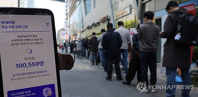'유심교체 예약 대기인원은' (서울=연합뉴스) 이진욱 기자 = SK텔레콤이 유심 고객정보 해킹 사고로 관련 유심 무료 교체 서비스에 나선 지난 28일 서울 시내 한 SK텔레콤 대리점 앞에서 한 고객이 유심 교체 예약을 QR코드로 등록하자 대기인원이 10만명 이상으로 나타나 있다. 2025.4.28 cityboy@yna.co.kr