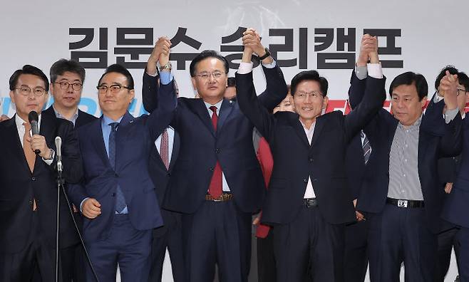 국민의힘 김문수 제21대 대통령 선거 경선 후보가 30일 서울 여의도 대하빌딩 후보 캠프 사무실에서 지지 선언을 위해 찾은 홍준표 전 대구시장 경선 캠프 소속 의원들과 함께 손을 맞잡고 있다.(사진=연합뉴스)