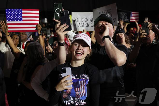 29일(현지시간) 미시건주 머콤 카운티에서 열린 도널드 트럼프 미국 대통령 취임 100일 기념 행사에서 시민들이 환호하고 있다. ⓒ 로이터=뉴스1