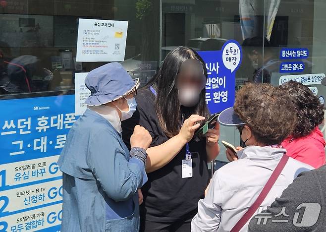 전북자치도 전주시의 한 SK텔레콤 대리점 직원이 유심 무상 교체 온라인 예약 방법을 안내하고 있다. 뉴스1/ 신준수 기자