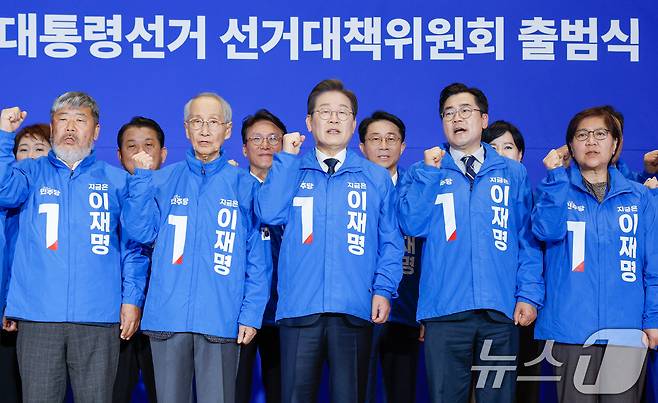 이재명 더불어민주당 대선 후보와 윤여준 상임 총괄선대위원장 등이 30일 오후 서울 여의도 국회 의원회관에서 열린 제21대 대통령선거 중앙선거대책위원회 출범식에서 선대위복을 입고 기념촬영을 하고 있다. 앞줄 왼쪽부터 김동명, 윤여준 위원장, 이 후보, 박찬대 당대표 직무대행 겸 원내대표, 정은경 선대위원장. 2025.4.30/뉴스1 ⓒ News1 안은나 기자