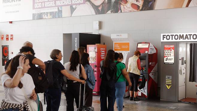 마드리드의 현금 자동 입출금기 앞에 줄 서 있는 사람들