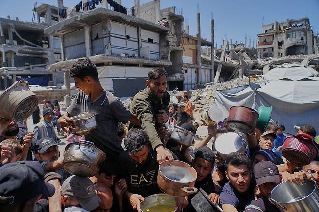 팔레스타인 사람들이 29일 가자지구 북부 베이트 라히아에 있는 배급소에서 음식을 받고 있다./AP 연합뉴스