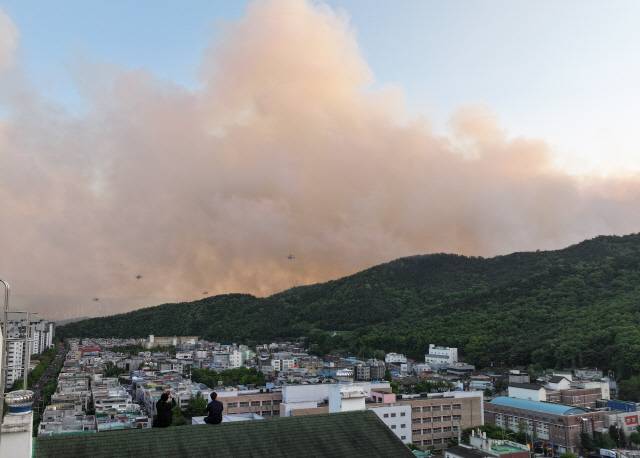 지난 28일 오후 2시 1분 대구 북구 노곡동 함지산에서 발생한 산불이 확산하고 있는 가운데 서변동 한 아파트 옥상에서 주민들이 산불 상황을 지켜보고 있다. [대구=연합뉴스]