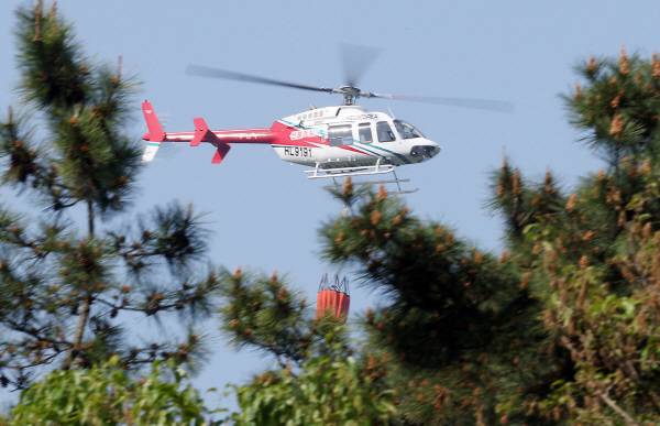 대구에서 발생한 대형 산불이 이틀 만에 진화됐다가 일부에서 재발화한 가운데 30일 대구 북구 산불 현장에서 소방헬기가 진화작업을 하고 있다. 연합뉴스