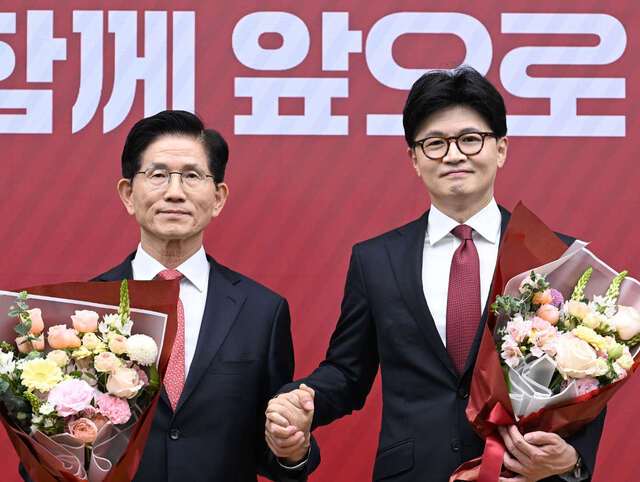 국민의힘 제21대 대통령 후보자 3차 최종 경선에 진출한 김문수(왼쪽) 후보와 한동훈 후보가 29일 서울 여의도 당사에서 결과 발표 후 손을 잡고 기념촬영을 하고 있다. 국회사진기자단