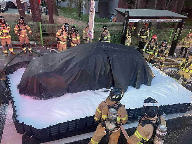 30일 오전 부산에서 운행중이던 전기차 택시에 불이 나 이동식 침수조와 질식포 덮개 등을 사용해 완전히 진화했다. [부산소방재난본부]