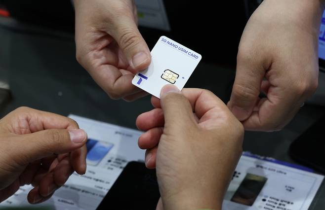 28일 오전 서울 시내 한 SKT 대리점에서 한 이용자가 교체할 유심을 받고 있다.  /사진=뉴시스