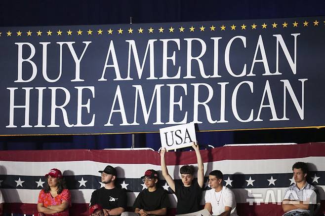 [워런=AP/뉴시스] 도널드 트럼프 미국 대통령의 지지자들이 29일(현지 시간) 미시간주 워런에 있는 매콤 커뮤니티 컬리지 스포츠 엑스포 센터에서 열린 취임 100일 기념 행사장에서 트럼프 대통령이 도착하기를 기다리고 있다. 2025.04.30.