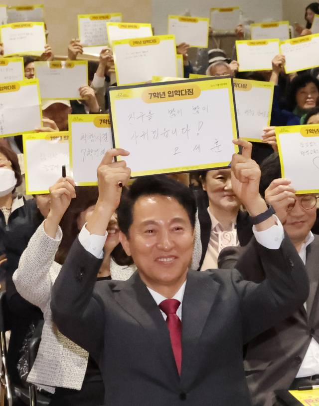 ▲24일 서울 관악구 서울시민대학 '다시 가는 캠퍼스'에서 열린 '2025년 7학년 교실 입학식'에서 오세훈 서울시장과 학생들이 '우리의 다짐'을 작성한 뒤 들어보이고 있다. ⓒ연합뉴스