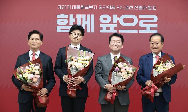 김문수, 한동훈, 안철수, 홍준표 국민의힘 대선 경선 후보가 29일 서울 여의도 중앙당사에서 열린 제21대 대통령후보자 선출을 위한 3차 경선 진출자 발표에서 결과 발표 후 꽃다발을 들고 기념촬영을 하고 있다. 뉴시스