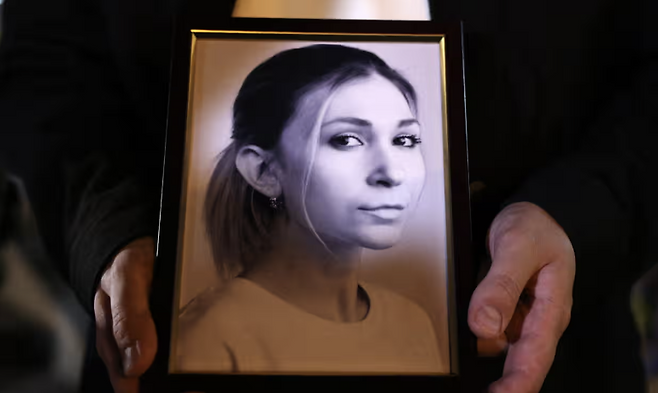 지난해 10월 빅토리야 로시나가 사망한 사실이 우크라이나에 통보되자 추모행사에서 동료가&nbsp; 로시나 사진을 들고 있는 모습. 가디언 캡처