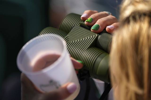 음료를 든 채 쌍안경으로 선수를 확인하는 페이트런(관람객). 전자기기와 깃발, 배너, 유모차, 외부 음식, 금속 스파이크가 박힌 골프화, 사다리, 셀피 스틱은 반입 금지지만 쌍안경은 괜찮다. AP연합뉴스