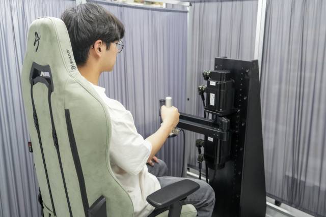 로봇을 이용한 상지 경직 진단 방식. 로봇 팔을 움직이면 사람 팔이 이에 반응하게 되는데, 이 반응을 신호로 측정해 경직도를 진단한다. 사진제공=유니스트