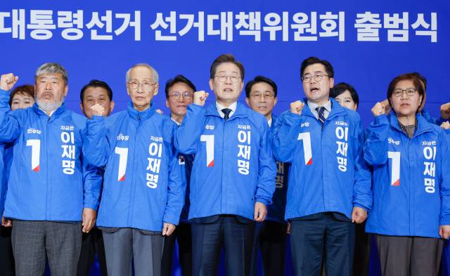 이재명(가운데) 더불어민주당 대선 후보가 30일 오후 서울 여의도 국회 의원회관에서 열린 제21대 대통령선거 중앙선거대책위원회 출범식에서 선대위복을 입고 기념 촬영을 하고 있다. 왼쪽은 총괄선대위원장으로 임명된 김동명 한국노총 위원장. 뉴스1