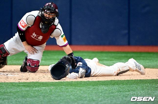 롯데 전민재(오른쪽)가 29일 키움전에서 7회초 헤드샷을 맞고 쓰러져 있다.