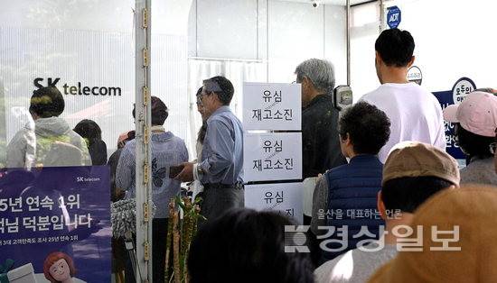 ▲ SK텔레콤 유심 해킹과 관련해 유심 무상교체가 시작된 가운데 울산지역 한 SK텔레콤 대리점에 유심재고 소진이라는 안내문이 붙어있다. 유심 예약접수를 하려는 시민들이 길게 줄지어 서있다. 김도현기자