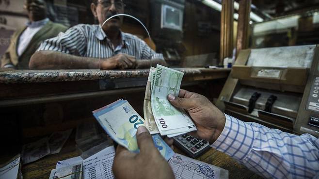 이집트 카이로의 한 직원이 지폐를 세는 모습