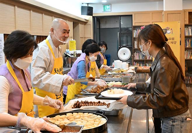 지난달 22일 오전 11시 40분쯤 서울 동대문구 연화사 공양간에서 연화사 주지 묘장 스님(왼쪽에서 두 번째)과 신도들이 '청년밥심' 프로그램에 참여한 대학생들에게 사찰 음식을 나눠주고 있다./ 고운호 기자
