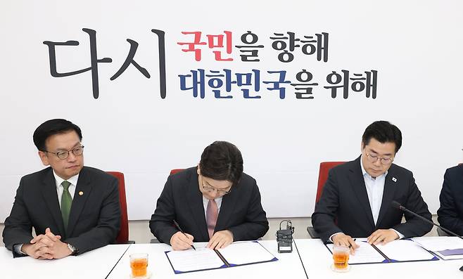 권성동(가운데) 국민의힘 원내대표와 박찬대(오른쪽) 더불어민주당 원내대표가 1일 오전 서울 여의도 국회에서 추경안 합의문에 서명하는 모습을 최상목 부총리 겸 기획재정부장관이 지켜보고 있다. /뉴스1