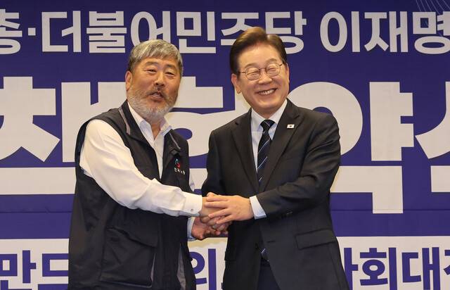 이재명 더불어민주당 대선 후보가 1일 오후 서울 중구 한국프레스센터에서 열린 한국노총과의 정책 협약식에서 협약서에 서명한 뒤 김동명 한국노총 위원장과 악수를 하고 있다. 신소영 기자 viator@hani.co.kr