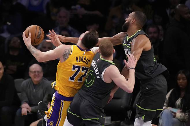 <yonhap photo-3144=""> Los Angeles Lakers guard Luka Doncic (77) collides with Minnesota Timberwolves guard Donte DiVincenzo (0) and center Rudy Gobert during the first half in Game 5 of an NBA basketball first-round playoff series Wednesday, April 30, 2025, in Los Angeles. (AP Photo/Mark J. Terrill)/2025-05-01 12:26:52/ <저작권자 ⓒ 1980-2025 ㈜연합뉴스. 무단 전재 재배포 금지, AI 학습 및 활용 금지></yonhap>