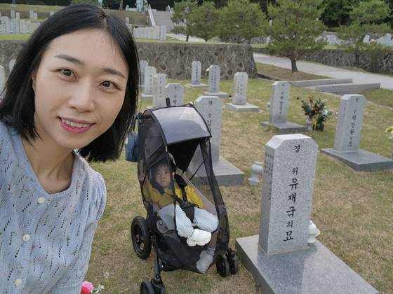 지난해 5월 고(故) 유재국 경위의 아내 이꽃님(38)씨와 강직성 뇌성마비를 앓고 있는 아들 유이현(5)군이 국립서울현충원에 있는 유 경위의 묘역을 방문했다. 사진 이꽃님씨