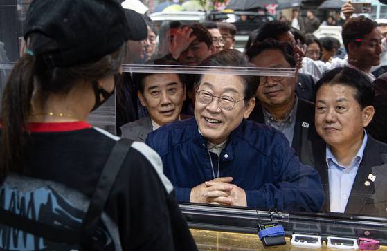 이재명 더불어민주당 대통령 후보가 1일 오후 경기도 포천시 신읍사거리 일대에서 치킨집 사장과 대화를 하고 있다. 뉴스1