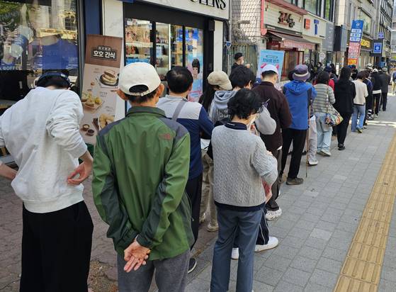 SK Telecom subscribers wait in line to replace their SIM cards at the mobile carrier's store in Seoul on April 26 after a hacking attack that leaked customer information on April 18. [YONHAP]