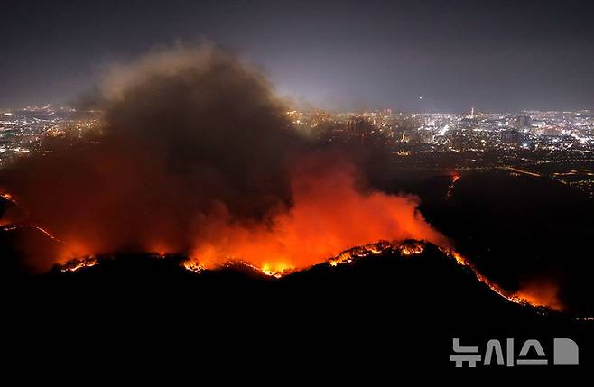 [대구=뉴시스] 이무열 기자 = 28일 밤 대구 북구 노곡동과 조야동 인근 산을 따라 불이 주택가 방향으로 확산하고 있다. 이날 오후 2시1 분쯤 대구 북구 노곡동 함지산에서 발생한 산불로 인해 민가 피해를 막기 위해 소방청은 국가소방동원령을 발령했다. 2025.04.28. lmy@newsis.com