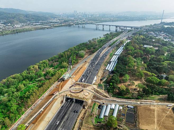 최초로 올림픽대로위에 조성된 암사 덮개 공원. 덮개 공원 좌우로 이어지는 암사 초록길은 암사동 선사유적지 일대와 암사 생태공원을 연결한다. 멀리 보이는 다리는 구리암사대교다. 강동구청 제공
