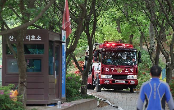 23시간 만에 진화됐다가 잔불 정리 중 재발화해 확산했던 대구 북구 함지산 산불이 다시 진화 완료된 1일 산불 현장 진입로에서 소방관계자들이 뒷불을 감시하며 만약의 사태에 대비하고 있다. 연합뉴스