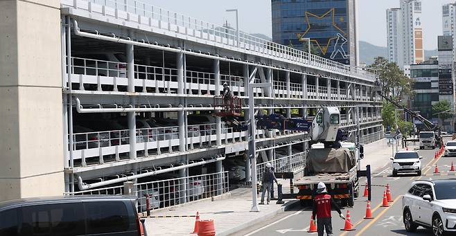 지난달 29일 오후 경남 창원시 마산회원구 창원NC파크 야구장 주차장에서 관계자가 외장 마감재 '루버' 철거 작업을 하고 있다./연합뉴스